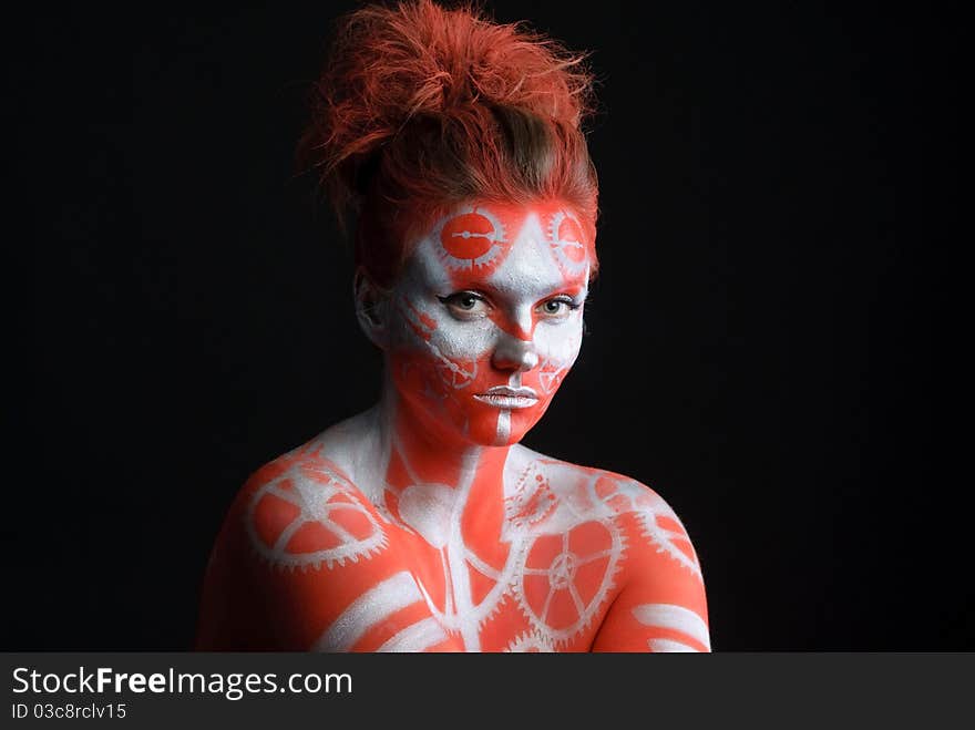 Mystic young woman with painted face looking at camera