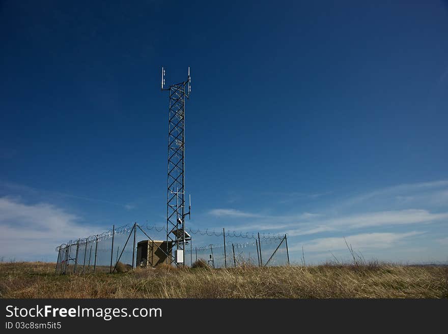 On a lone mountaintop an antenna stretches into the sky to communcate the messages its been given. On a lone mountaintop an antenna stretches into the sky to communcate the messages its been given.