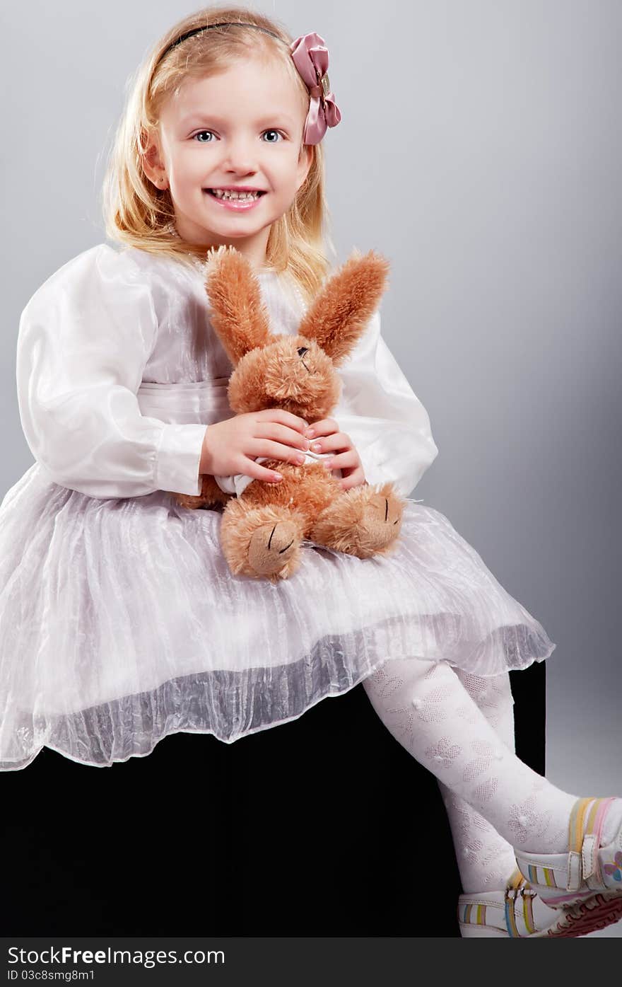 Little Girl Hugging Bear Toy And Smiling