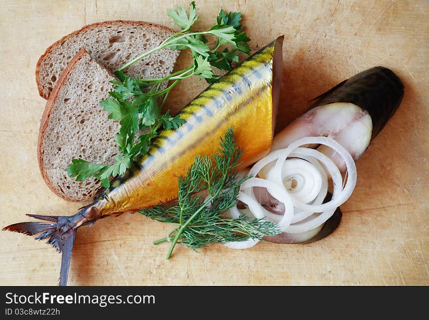 Sliced bloated fish and bread on wooden surface