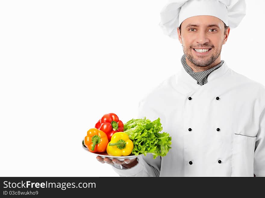 Attractive chef with a plate with vegetables on white background. Attractive chef with a plate with vegetables on white background