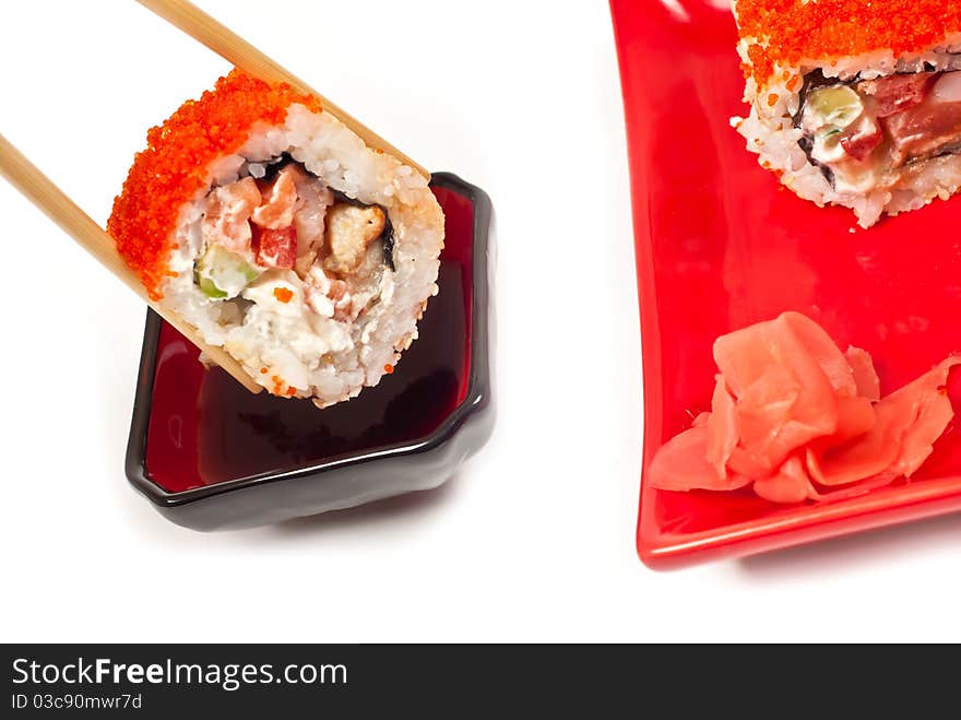 Sushi rolls served in chopsticks . White background