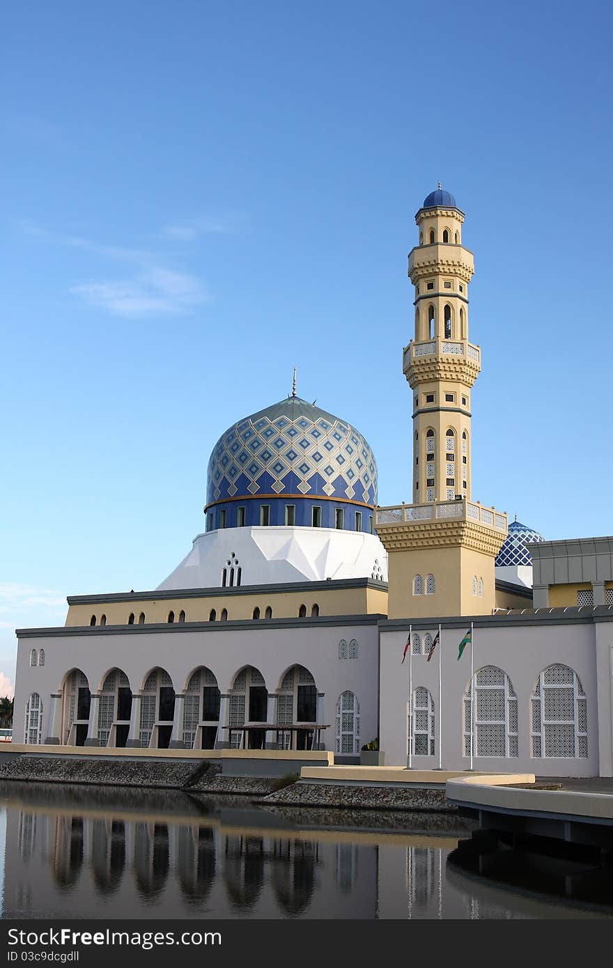 A mosque near a pond under a sunny day. A mosque near a pond under a sunny day