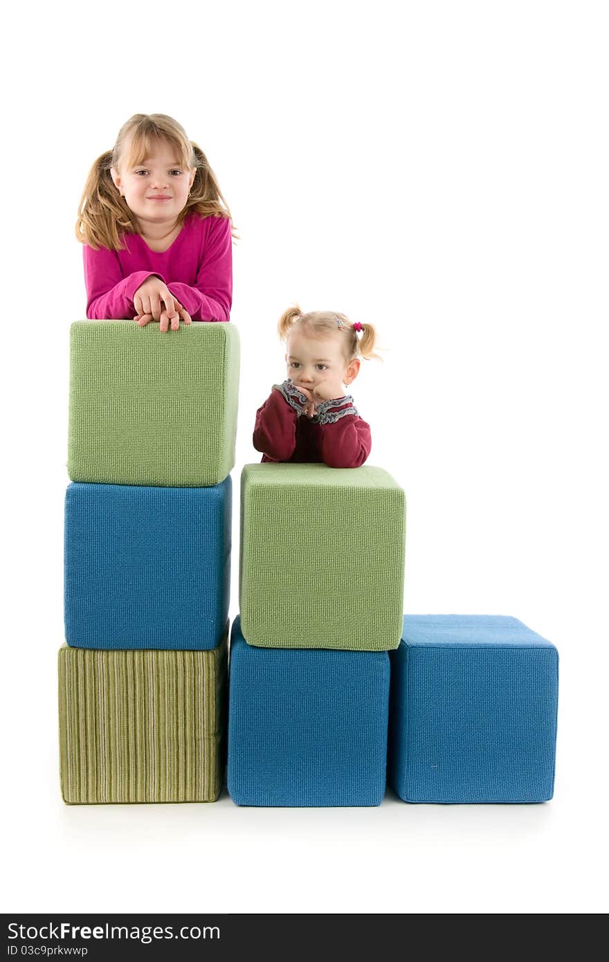 Merry girls with big cube on playing, on white background. Merry girls with big cube on playing, on white background.