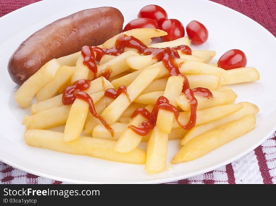 The fried potato is watered by ketchup with sausage and tomatoes.