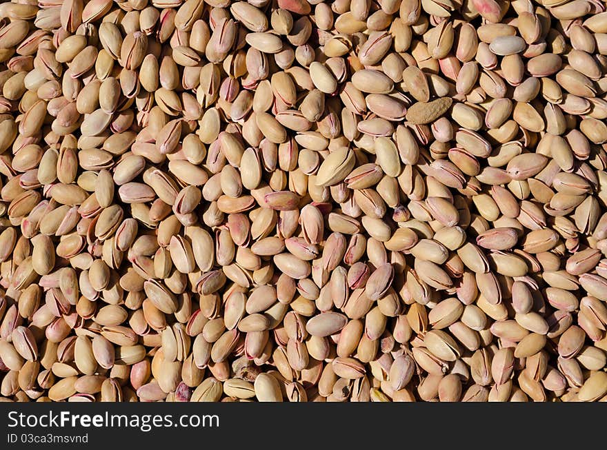 Bunch of salted roasted pistachios with salt in the market