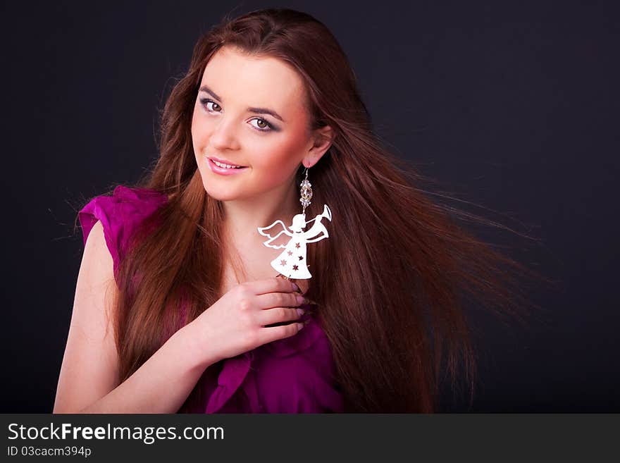 Beautiful long-haired brunette in a dress of fuchsia with sparkle earring. Beautiful long-haired brunette in a dress of fuchsia with sparkle earring