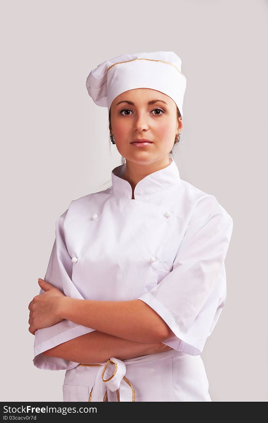 Young woman in white chef dress with hat. Young woman in white chef dress with hat