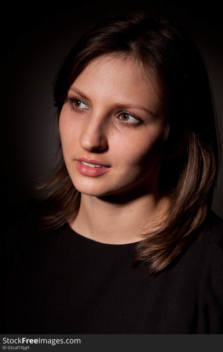 Portrait of the young beautiful girl on black