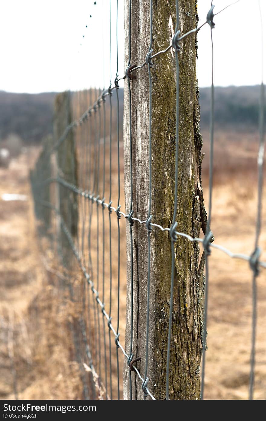 Wooden fence with metal netbarbed wire