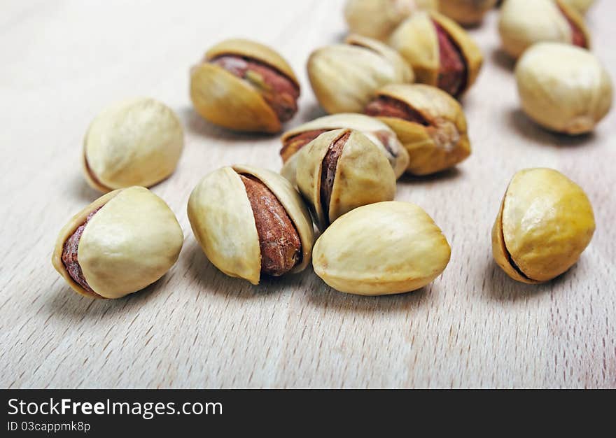 Beautiful pistachio seeds on wood close up