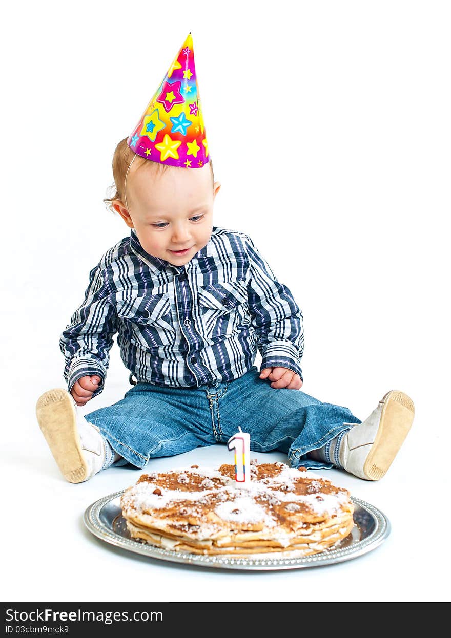 First birthday. Cute little boy in a cap with a birthday cake and a candle