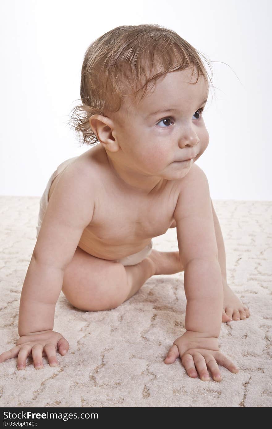 The charming boy sits on a carpet