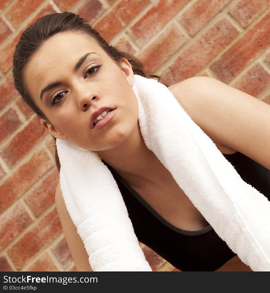 A young girl with a towel around her neck on a brick background. A young girl with a towel around her neck on a brick background