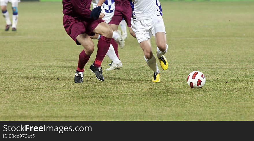 Soccer players running after the ball