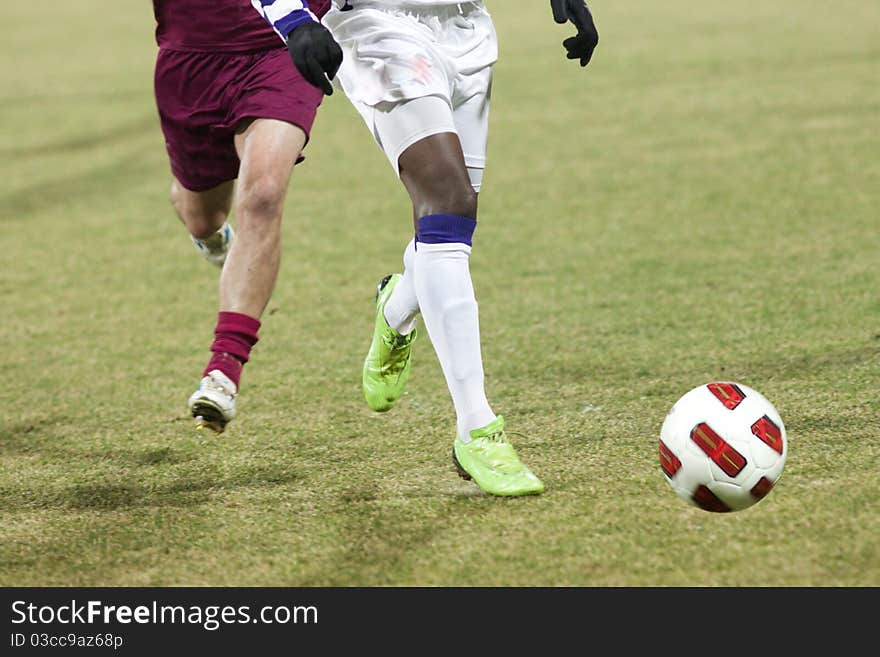 Soccer players running after the ball