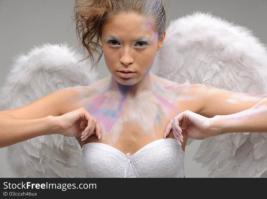 Girl with wings touch bra and posing