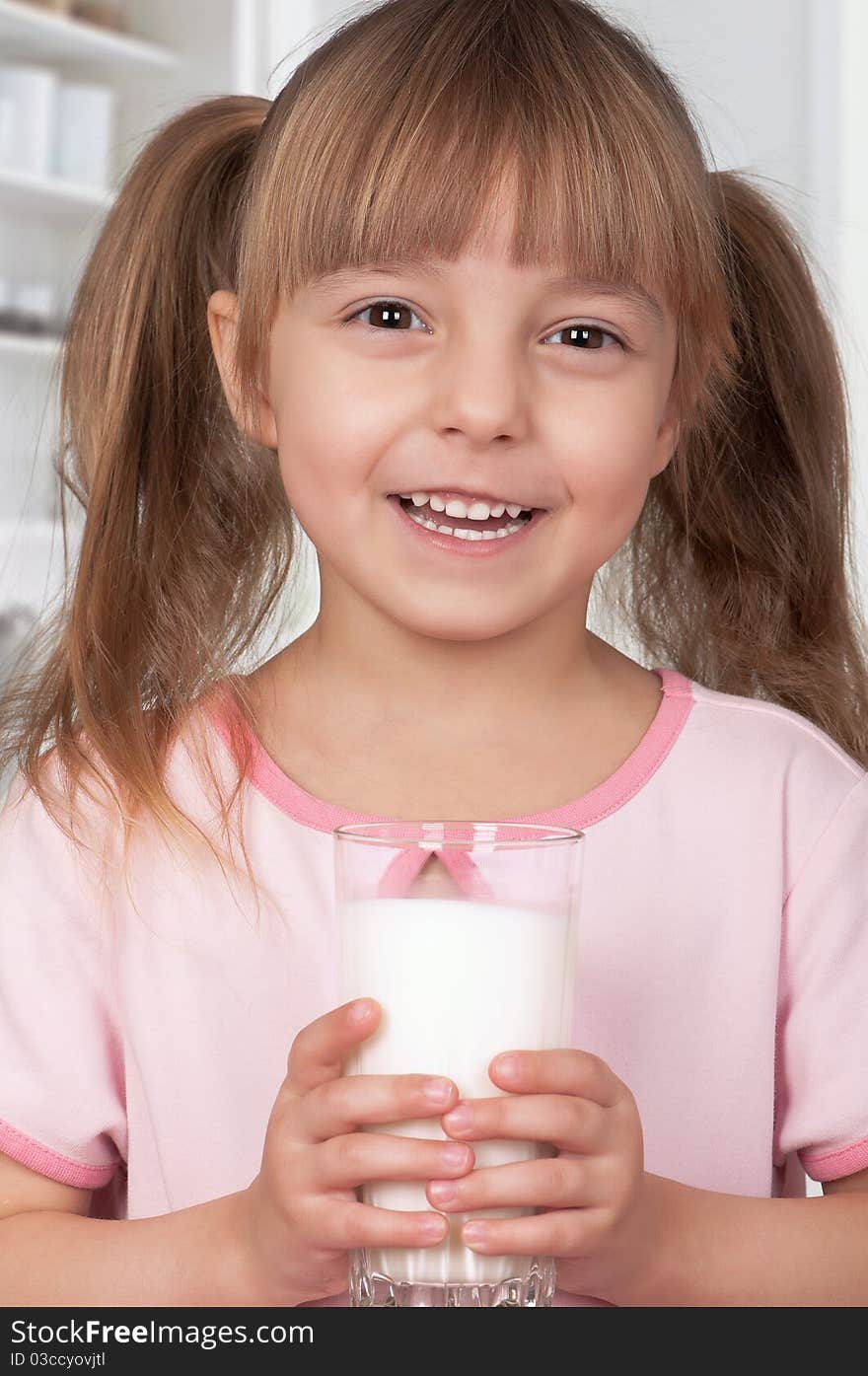 Cute little girl and glass of milk in kitchen. Cute little girl and glass of milk in kitchen