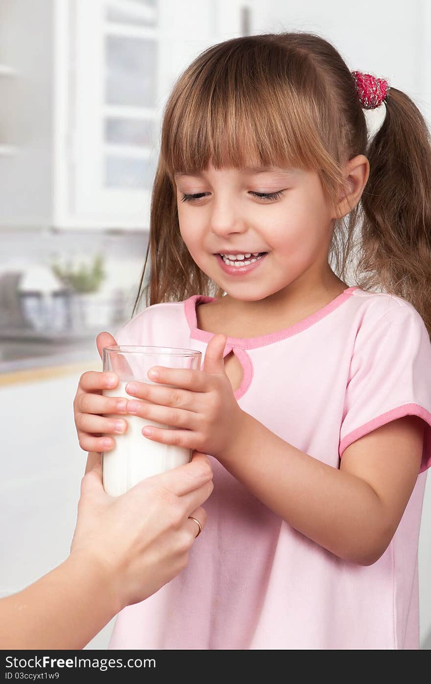 Cute little girl and glass of milk in kitchen. Cute little girl and glass of milk in kitchen