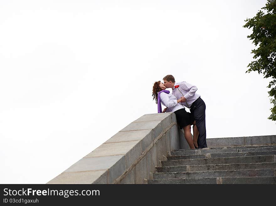 Romantic kiss on the stone stairs on white background