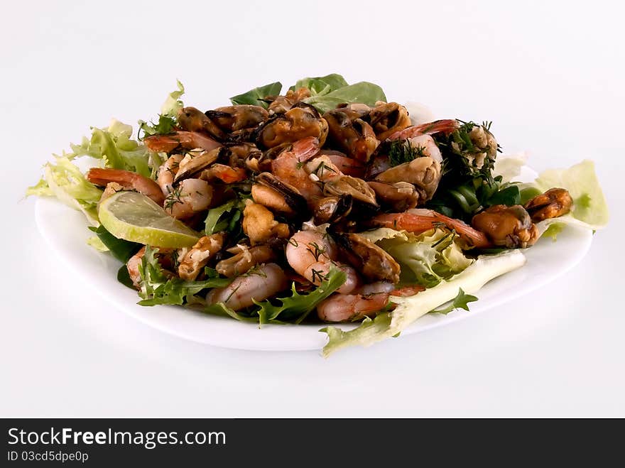 A salad with seafood on a white plate