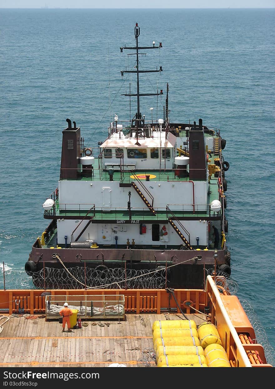 Two ships moored stern to stern during fueling operations.