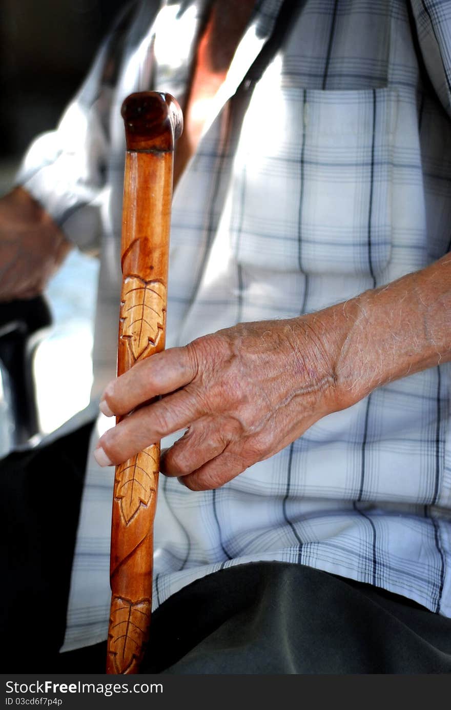 Elderly hand holding a cane. Elderly hand holding a cane