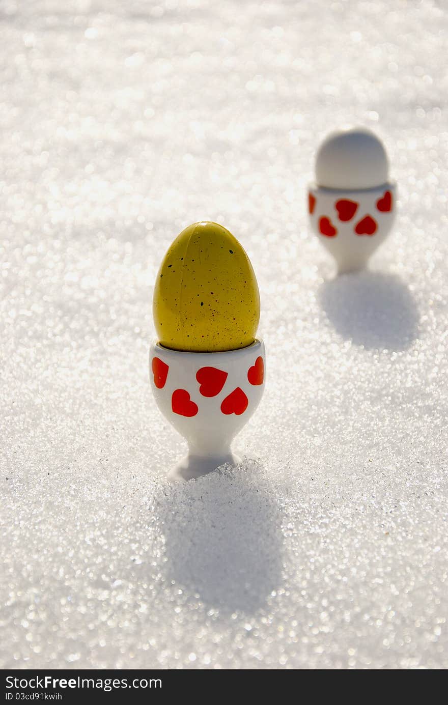 Color Easter eggs on spring snow background