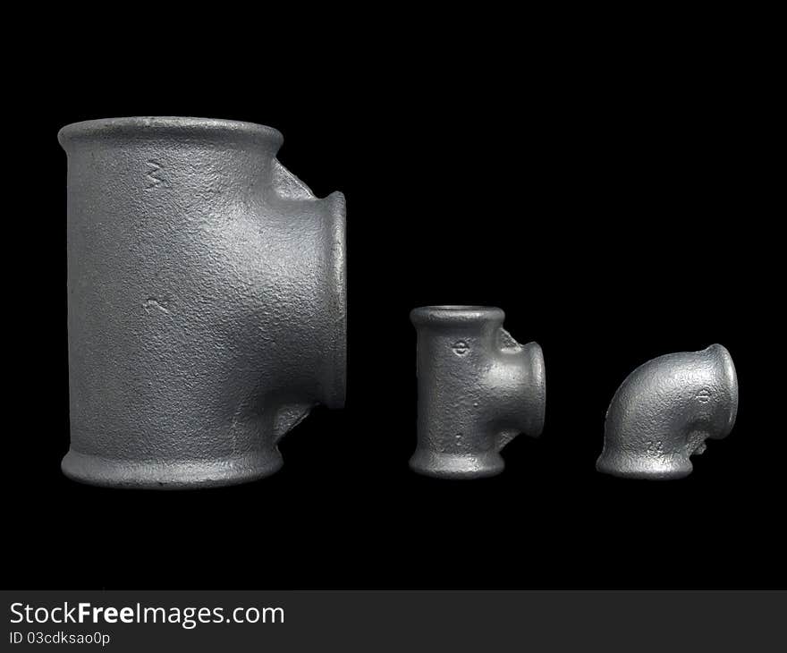 Different size of plumbing zinc coated fittings isolated on pure black background