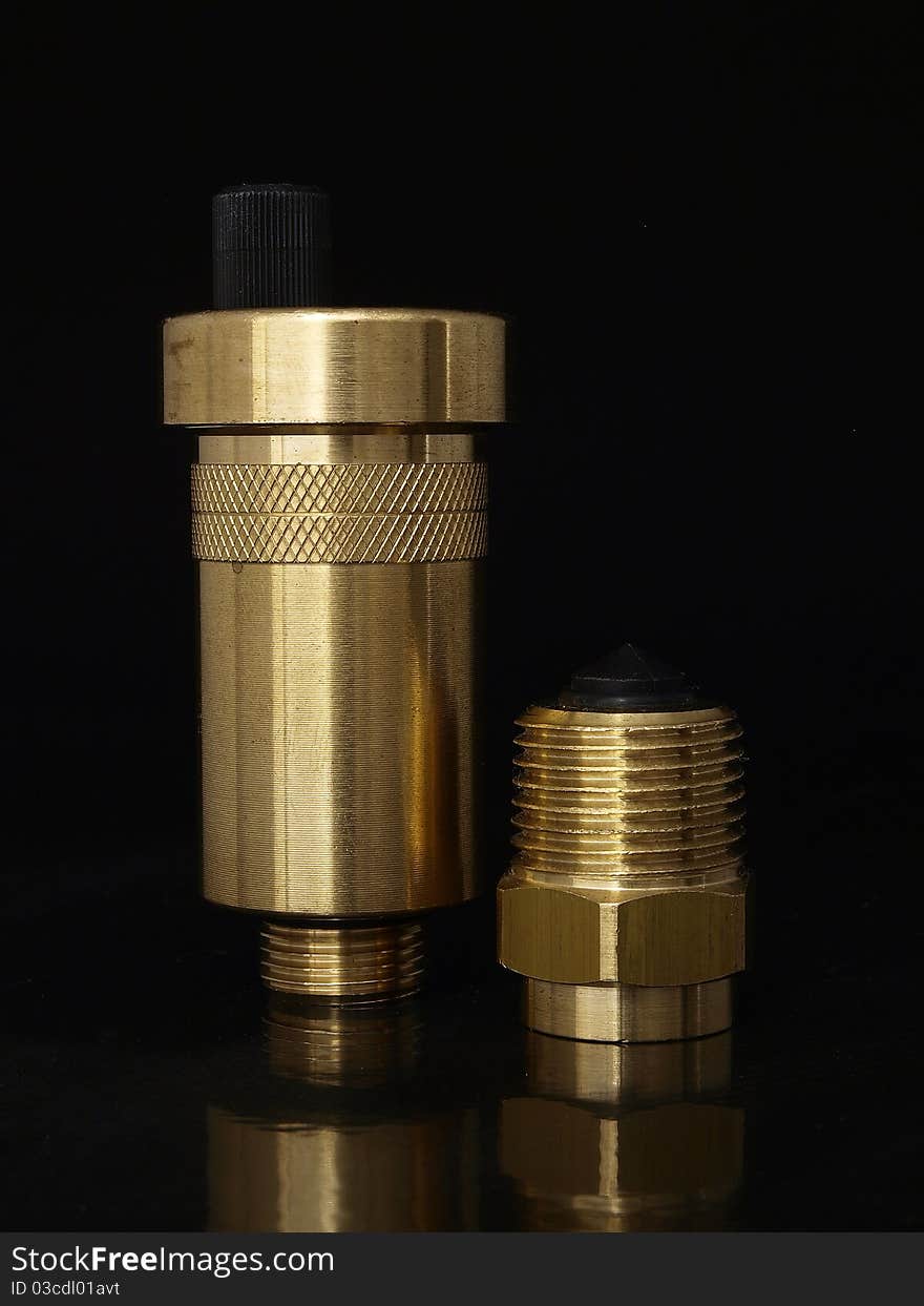 Golden brass desaerator and automatic valve over black background