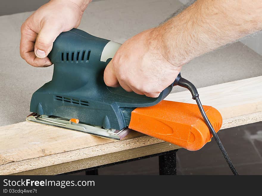 A man working with electrical sanding machine, close up on tool, hands and sparks, real situation picture. A man working with electrical sanding machine, close up on tool, hands and sparks, real situation picture