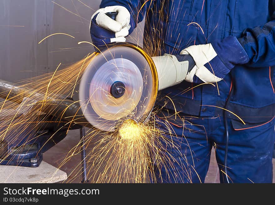 A man working with grinder, close up on tool, hands and sparks, real situation picture. A man working with grinder, close up on tool, hands and sparks, real situation picture