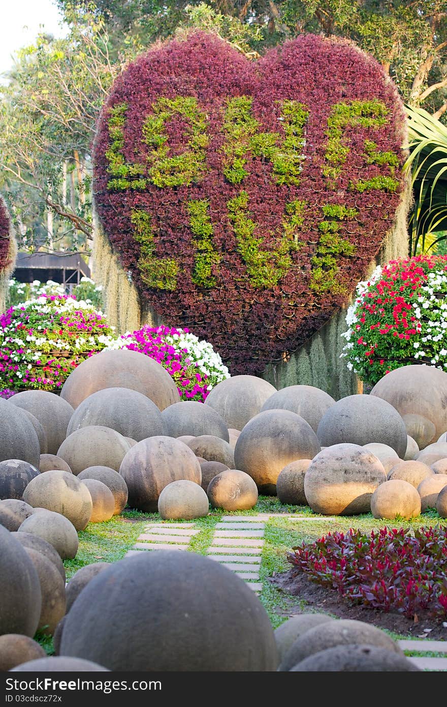 Heart made ​​of flowers surrounded by round stones. Heart made ​​of flowers surrounded by round stones