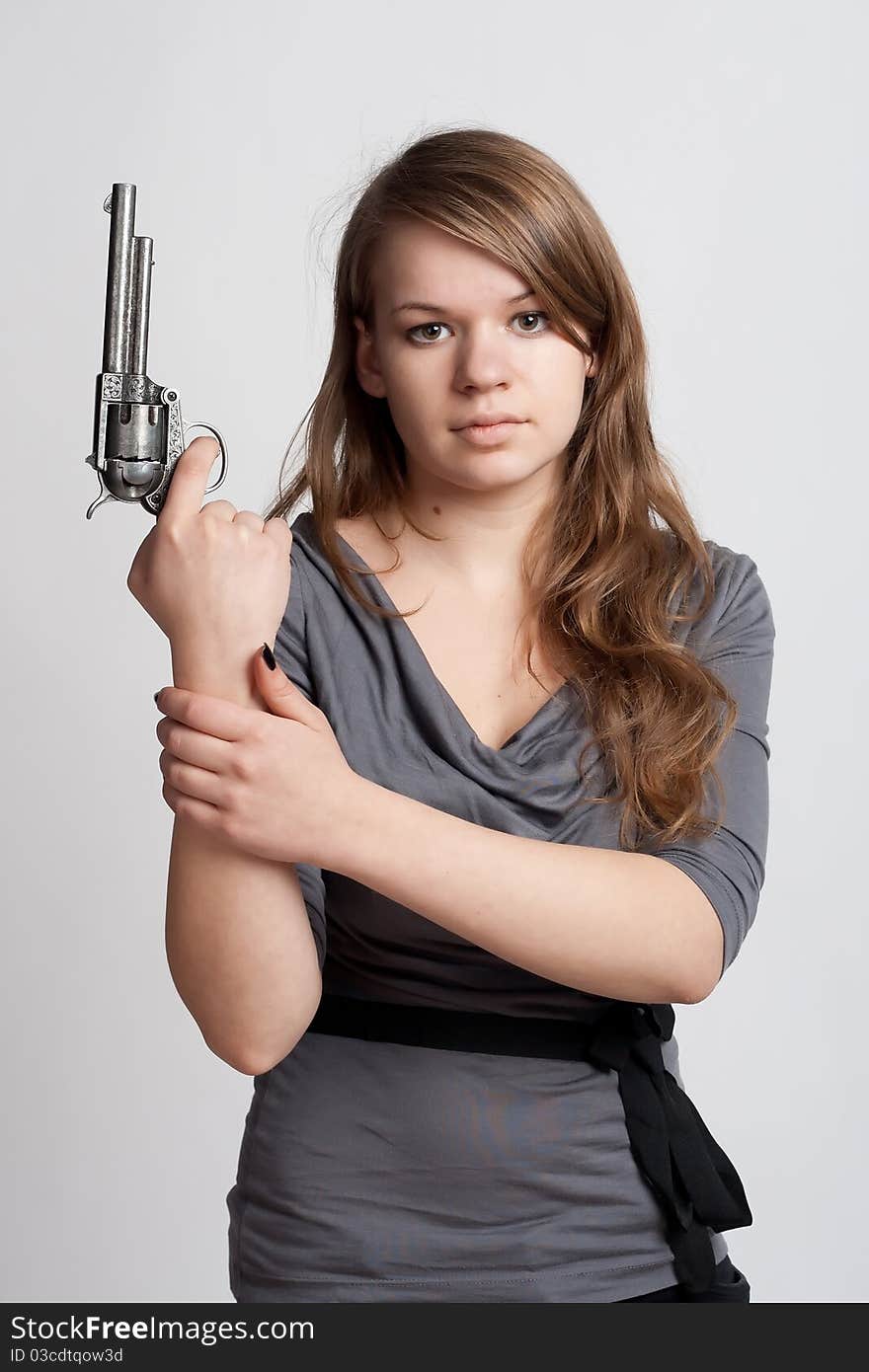 Girl with a gun on a light background. Girl with a gun on a light background