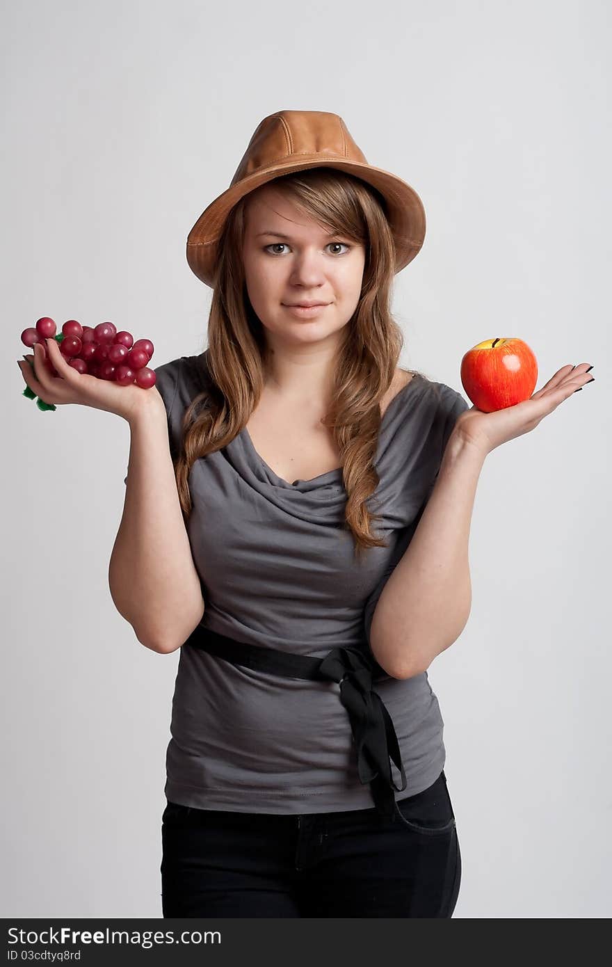 Girl with grapes and apples in the hands of