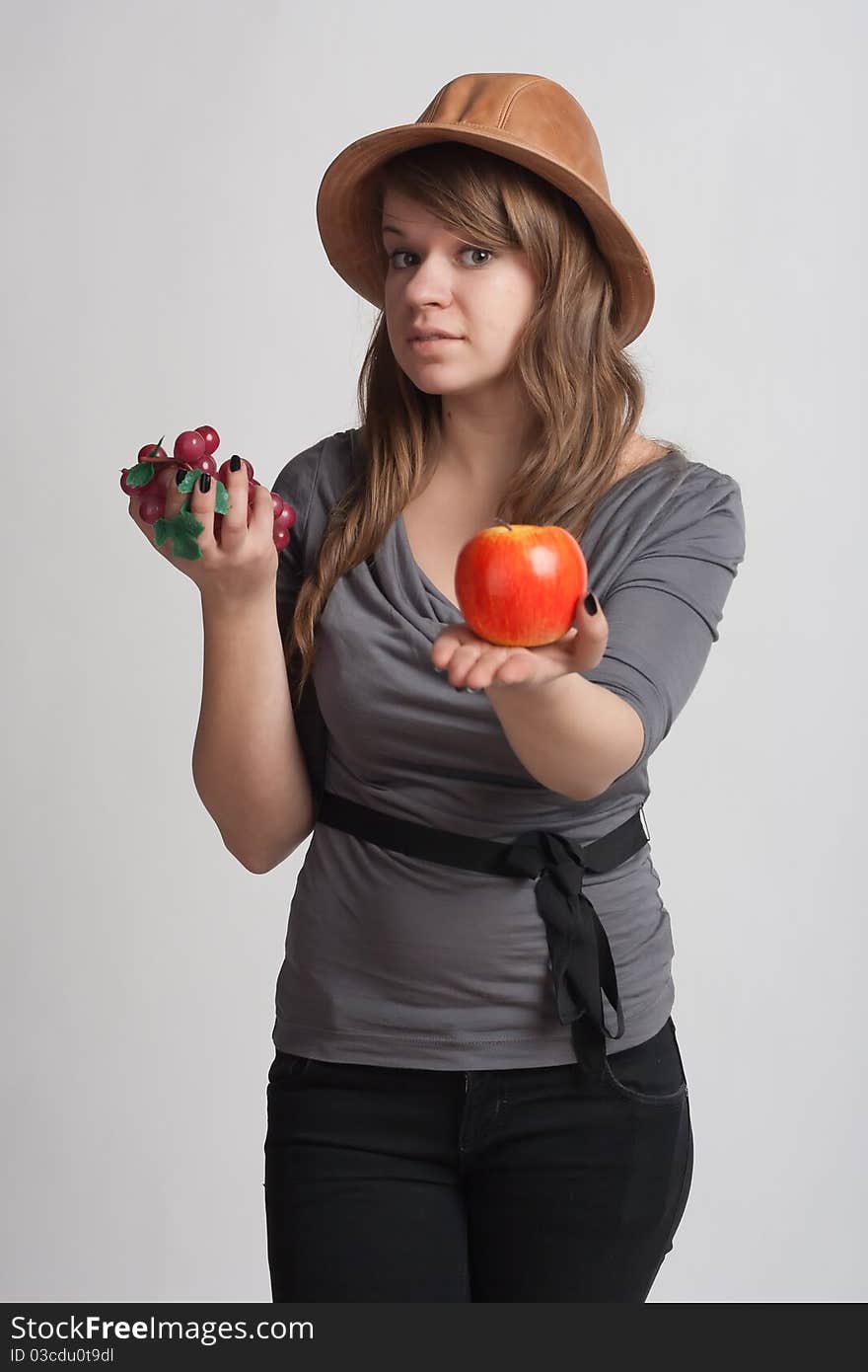 Girl with grapes and apples in the hands of