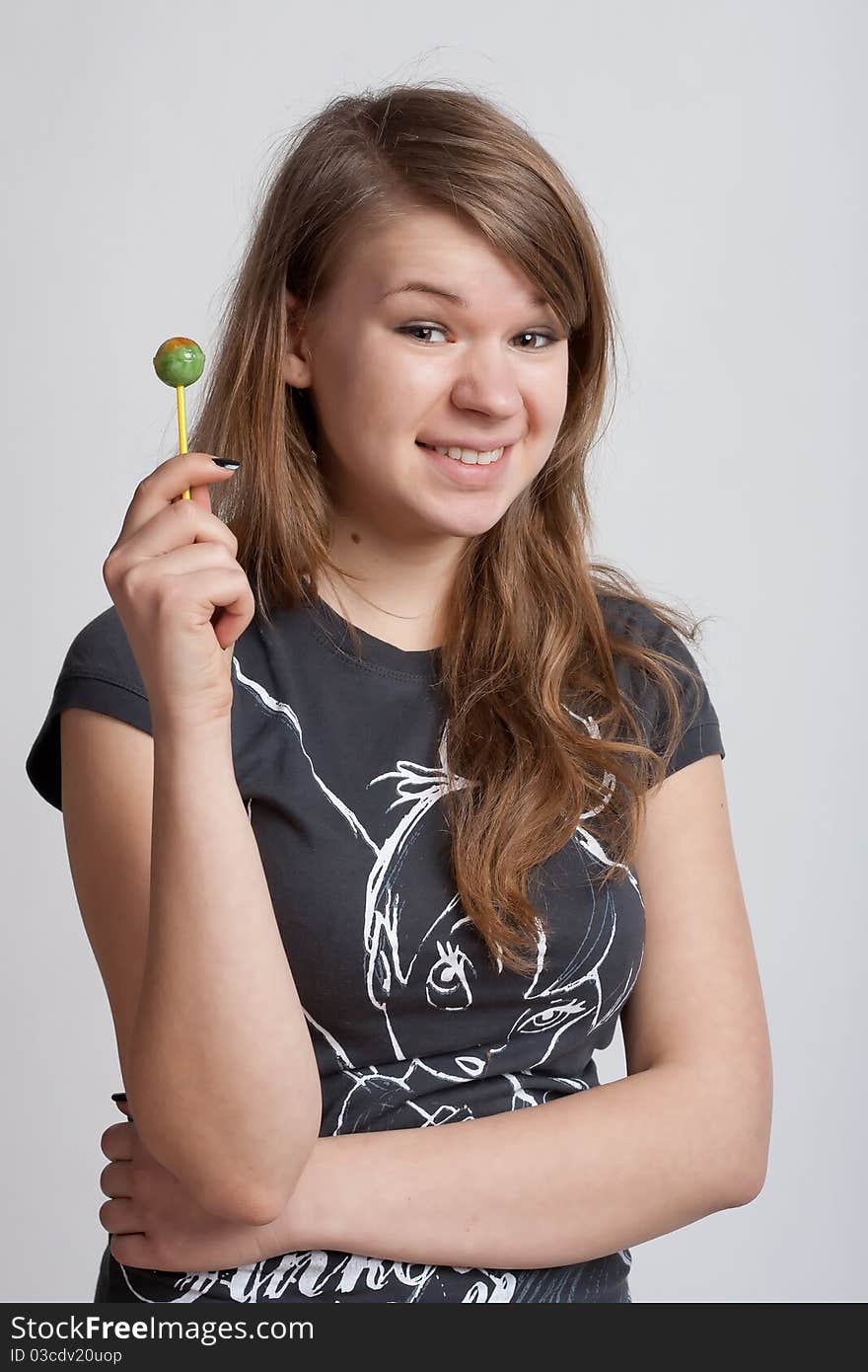 Girl on a white background with candy on a stick in his hand. Girl on a white background with candy on a stick in his hand