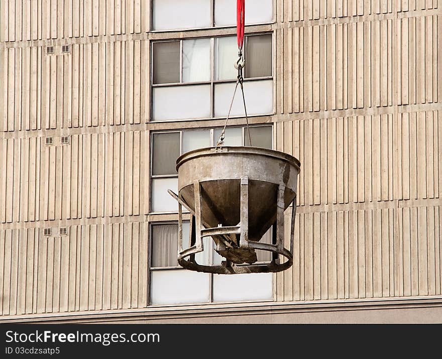 Cement bucket swinging against building