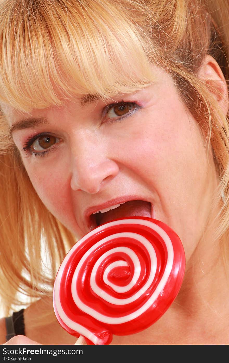 Middle aged woman enjoying a lollipop. Middle aged woman enjoying a lollipop