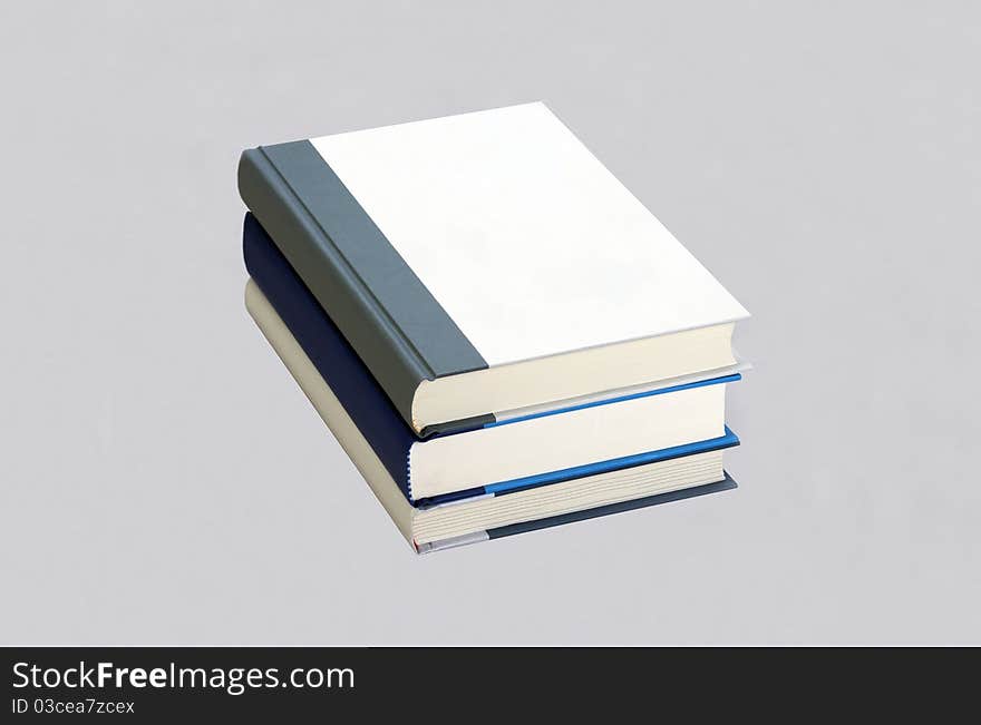 Three plain books in the stack