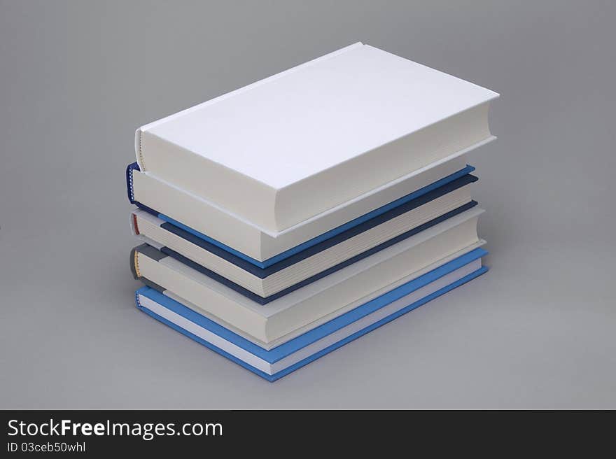 A bunch of 5 books with white plain book on the top. A bunch of 5 books with white plain book on the top