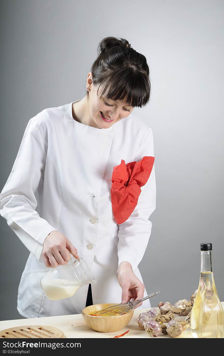 Girl mixing milk with eggs