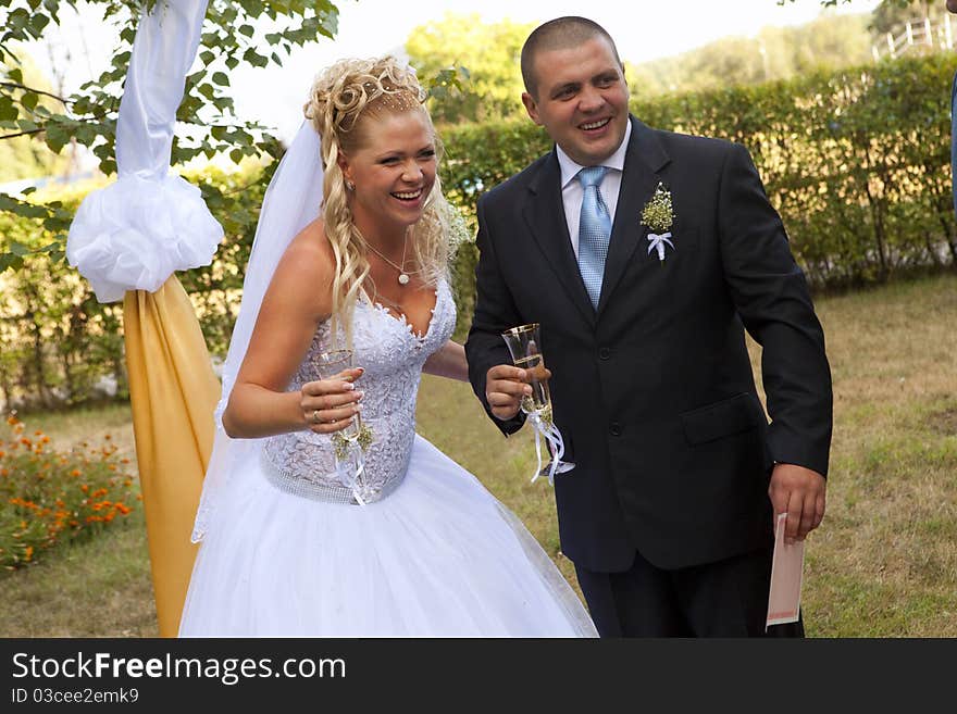 Bride and groom with champagne glasses smiling. Bride and groom with champagne glasses smiling