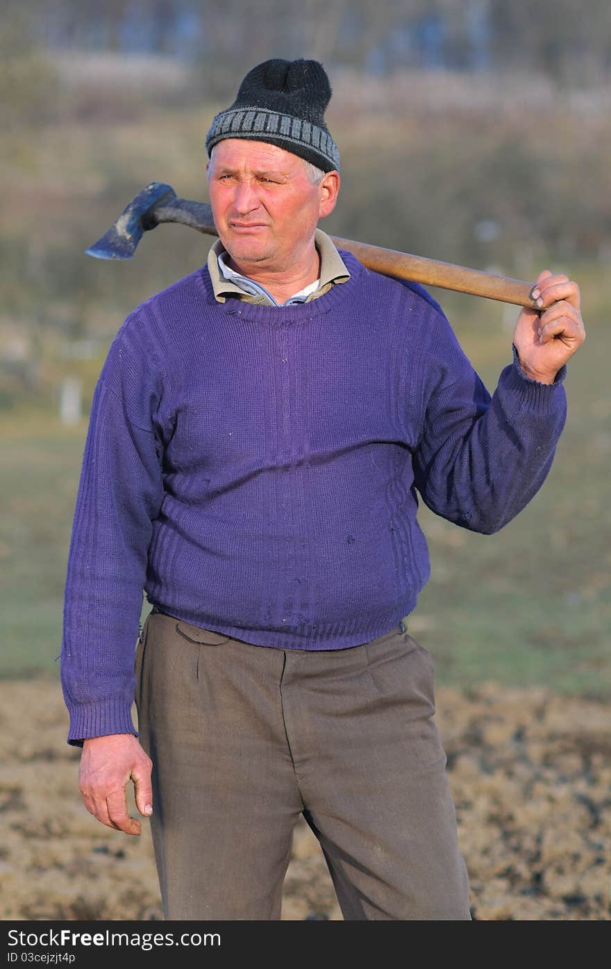 Torso portrait of a woodcutter near the forest with a hatchet on his shoulder. Torso portrait of a woodcutter near the forest with a hatchet on his shoulder.