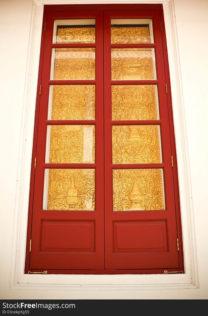 Gold and red ancient window of a temple in bangkok, thailand