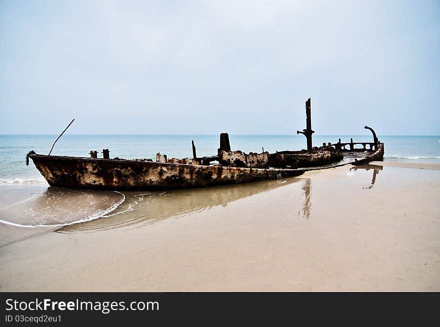 An old rusty ship thrown on a deserted beach. An old rusty ship thrown on a deserted beach