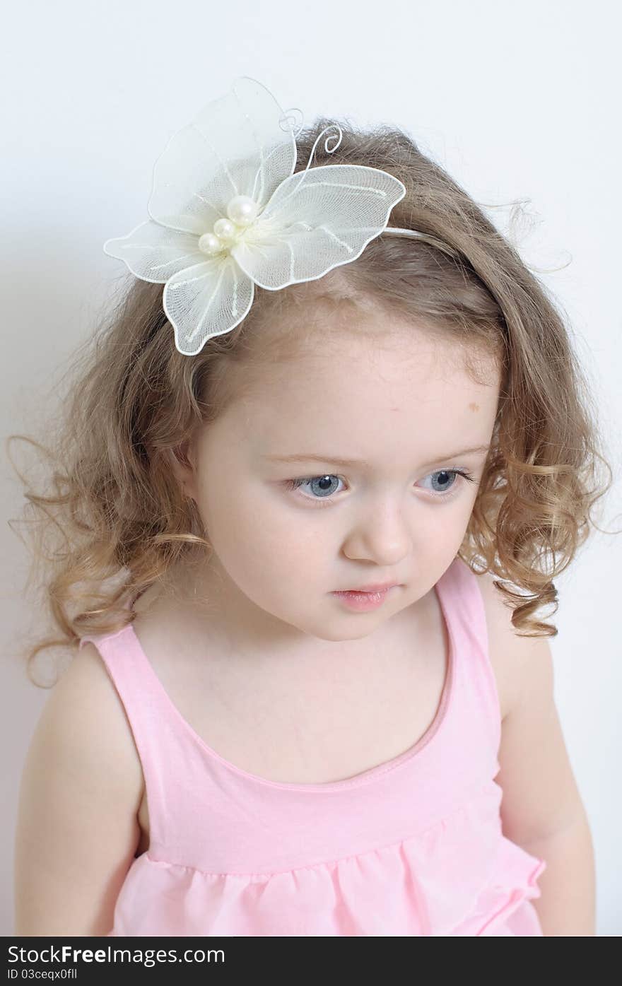 Girl in a pink dress in a white room