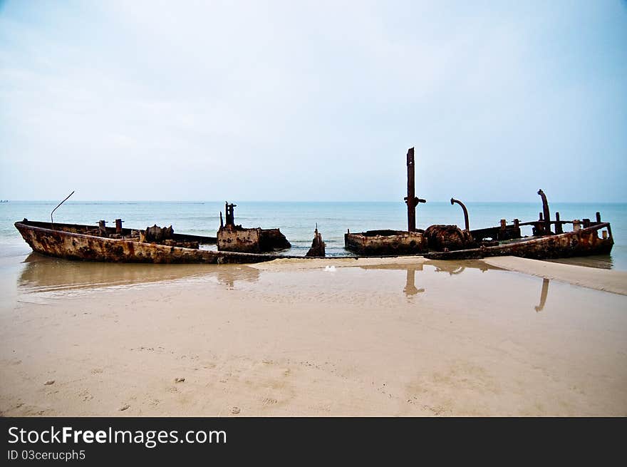 An old rusty ship thrown on a deserted beach. An old rusty ship thrown on a deserted beach