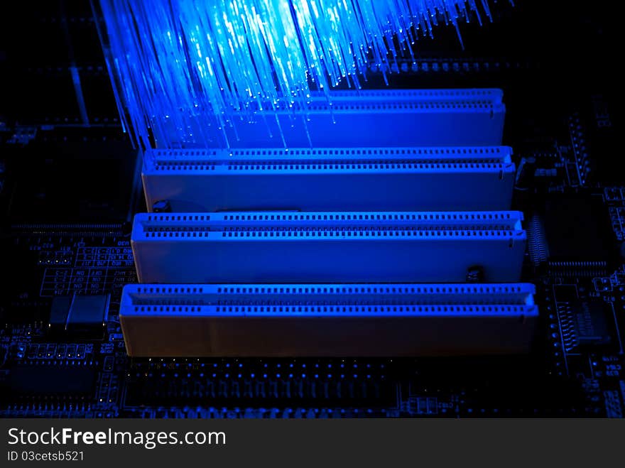 Photo of computer motherboard with fiber optics background. Photo of computer motherboard with fiber optics background