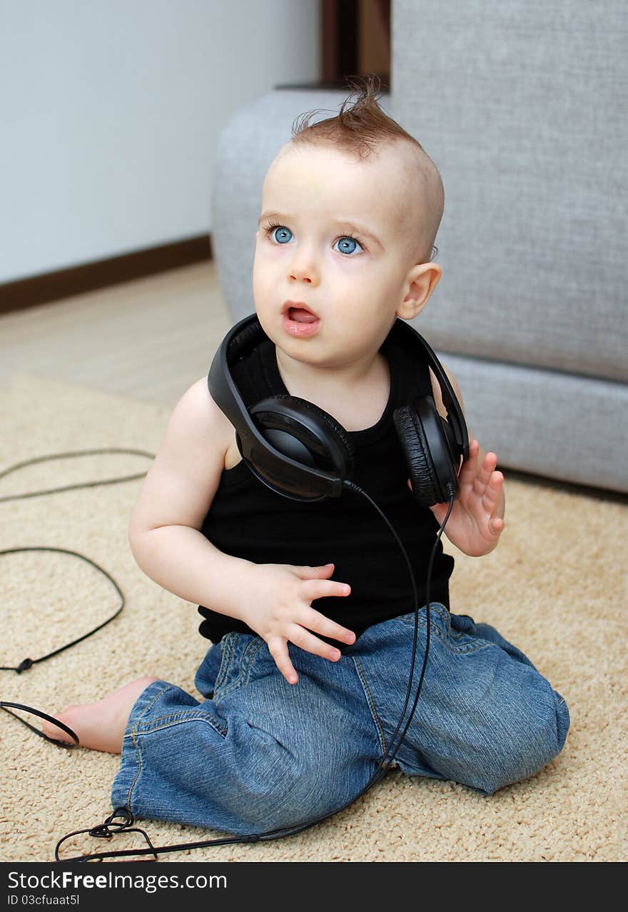 Portrait of serious baby in the earphones, background. Portrait of serious baby in the earphones, background